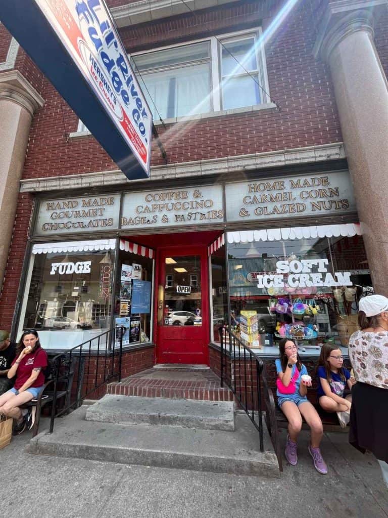 Sweet treat break in Alexandria Bay on a Thousand Islands 1 Day Itinerary with Kids Family eating ice cream in front of an ice cream shop in downtown Alexandria Bay NY