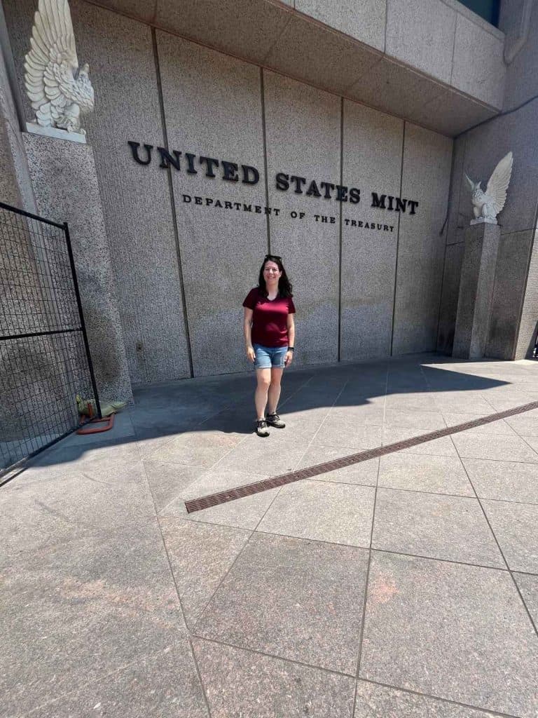 A mom standing in front of the United States Mint Department of the Treasury stone building in Philadelphia.