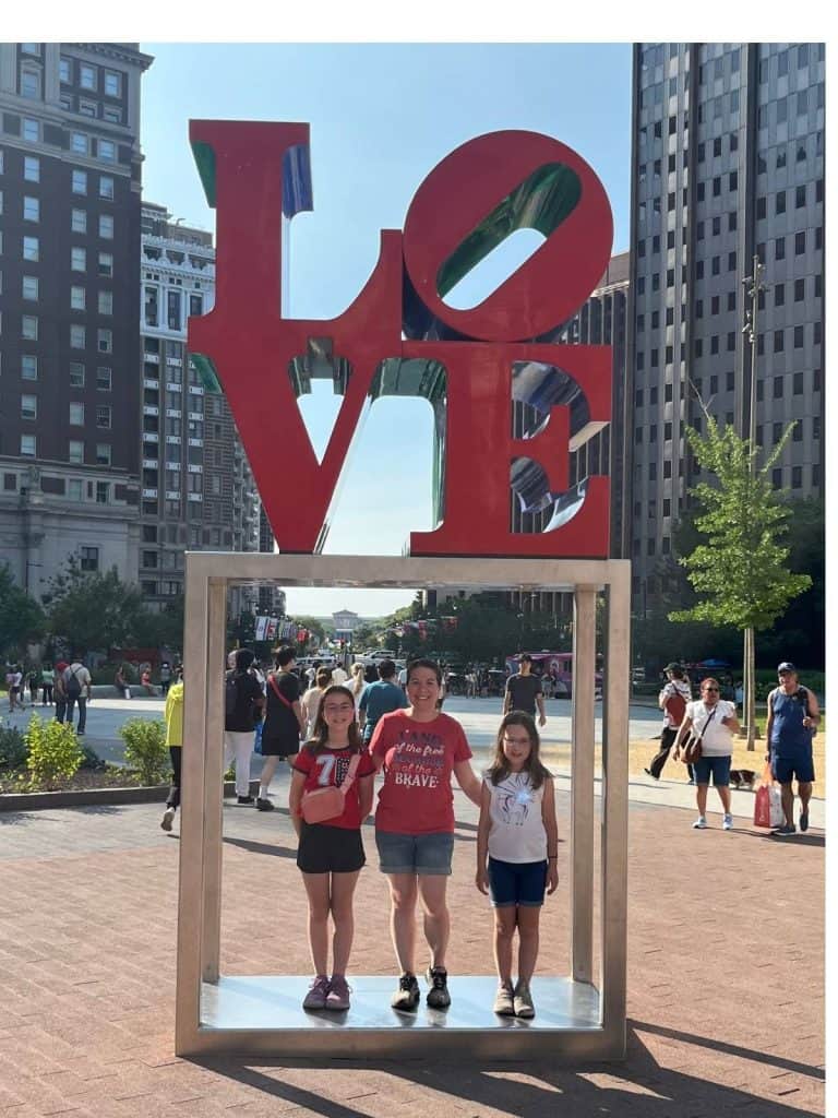 A family standing under the LOVE Philadelphia sign.